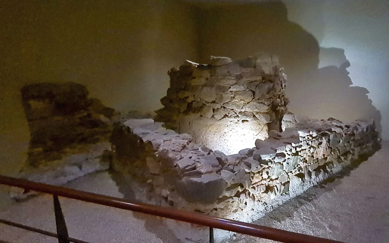 Excavated stone wall remains preserved under lights in the archaeological basement beneath the Museo Picasso Málaga