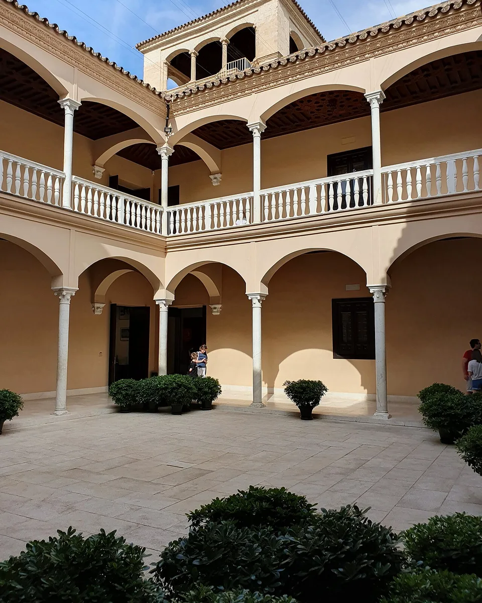 Sunlit Renaissance patio of the Palacio de Buenavista, seen from under the arcade of the Museo Picasso Málaga